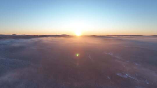 曙光照耀冻雾迷漫的林海雪原