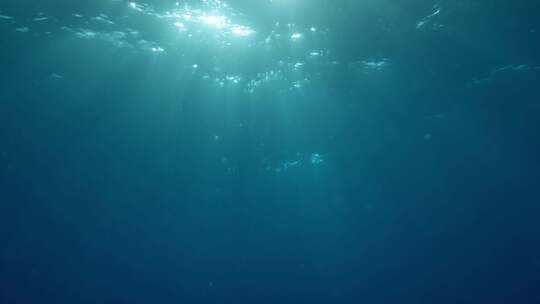 水下光线穿过深蓝色的海浪