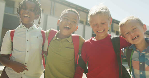 快乐的多样化男孩在学校前行走和大笑的视频