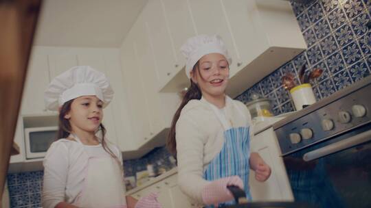 两个小女孩在厨房颠勺