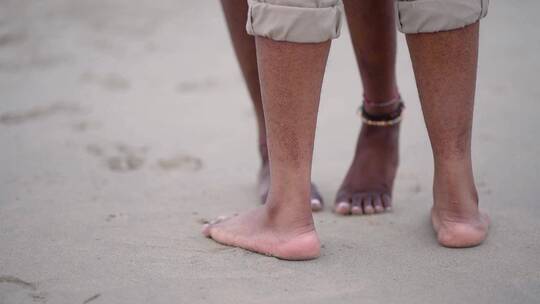 实拍沙滩上情侣的脚