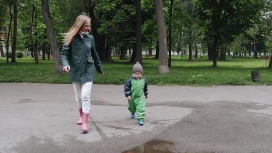 穿着雨靴的孩子在公园玩耍