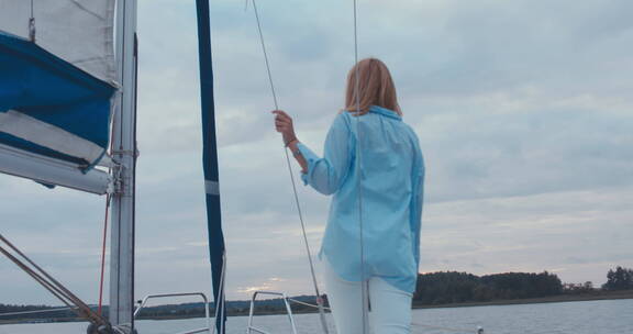 年轻女人独自站在帆船上