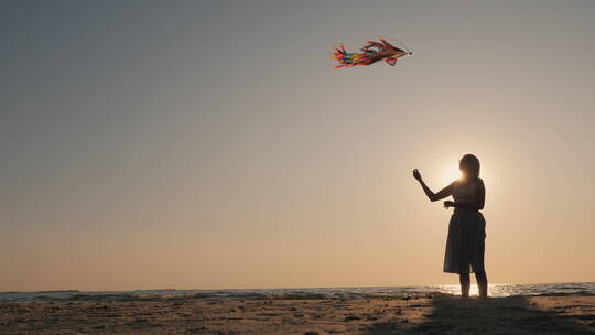 女人带着风筝的剪影