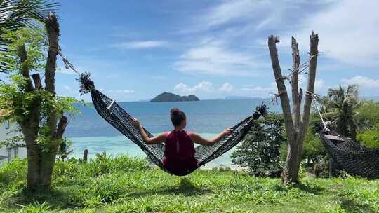 吊床上的女人看着大海