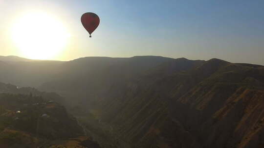 日落时，热气球飞过山谷和亚美尼亚村庄