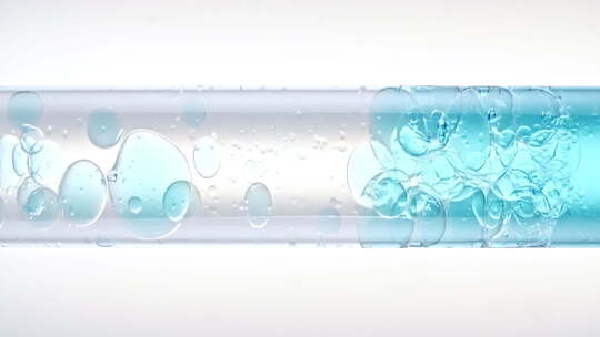 白色玻璃试管中不同尺寸清水气泡上升的宏射