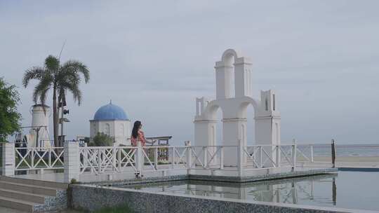 海边白色建筑旁的女子