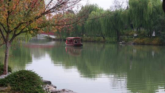 扬州瘦西湖阴雨天在雨中行驶的摇橹船及船娘