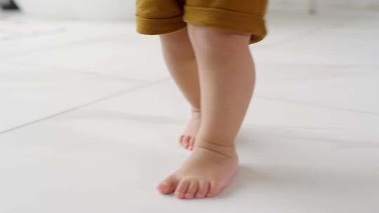 光脚婴儿在地板上学习走路