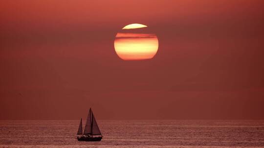 海边的日出与帆船
