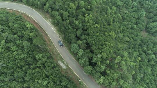 汽车行驶在林间公路的上空航拍