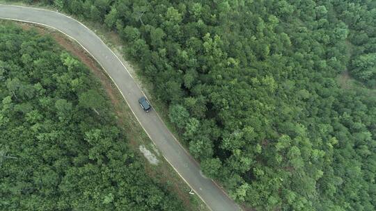 汽车行驶在林间公路的上空航拍视频素材模板下载