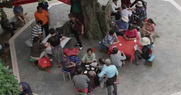 户外老年人围坐打牌休闲娱乐场景