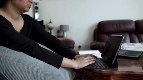 英国亚洲女性青少年将钢笔放在数字平板电脑
