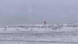航拍男子走在新疆禾木村的风雪中高清在线视频素材下载