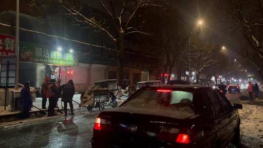 夜晚街道下雪环卫工人清理路面