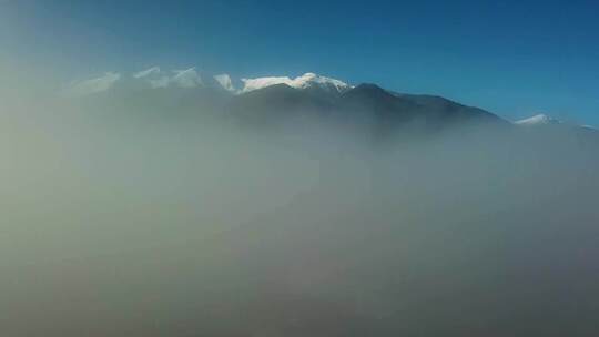 航拍被大雪覆盖的山脉山峰云雾缭绕