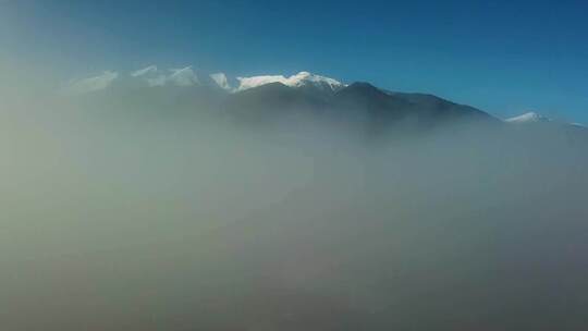 航拍被大雪覆盖的山脉山峰云雾缭绕视频素材模板下载