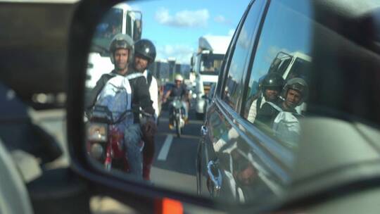 国外道路堵车后视镜中摩托车经过