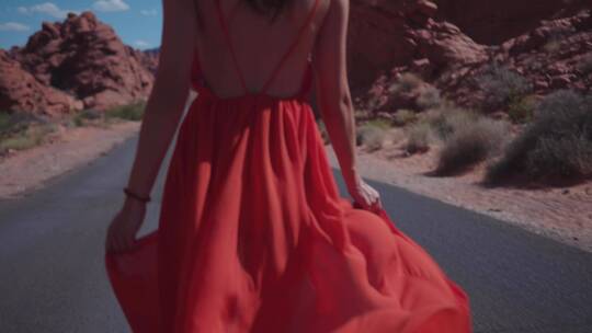 女人穿着红色太阳裙在公路上行走