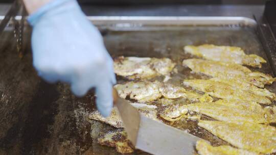 厨师使用铲子把鱼翻过来煎烤视频素材模板下载