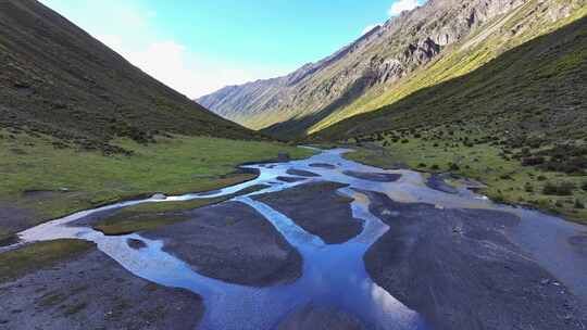 航拍四川甘孜乌库楚雪山下的草原溪流