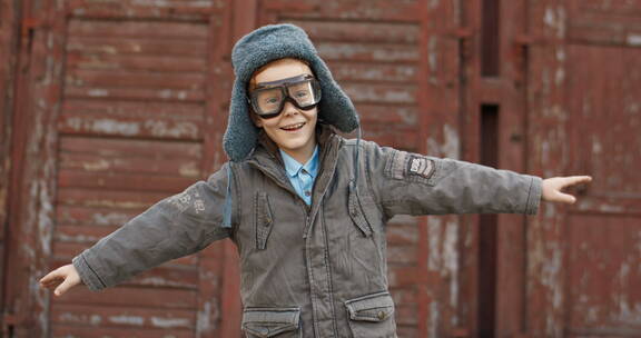 小男孩戴着飞行员护目镜张开双臂