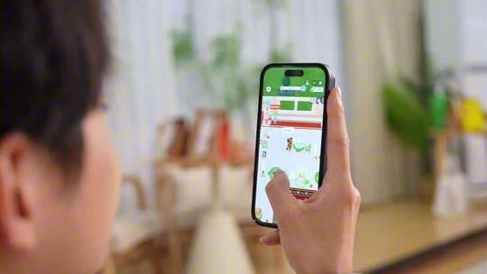 男子休闲居家手机玩游戏