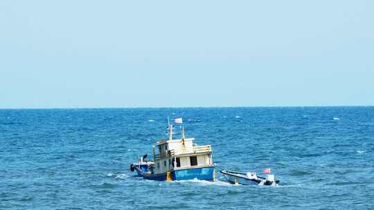 在海面风浪中摇曳的出海捕鱼的渔船