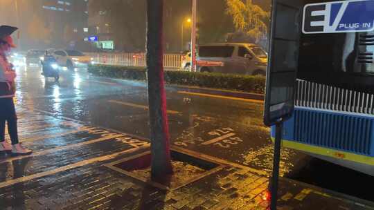 雨天夜晚下雨公交车站行人马路积水