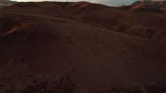 日落时分，一个人在阿拉蒂红山徒步旅行