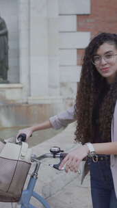 漂亮的摩洛哥女孩与自行车微笑和摆姿势在相