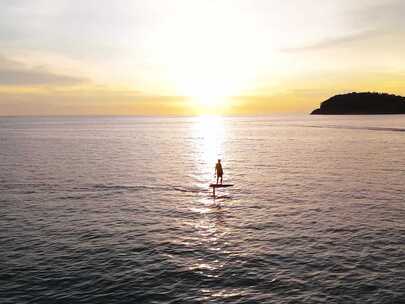 男人使用动力冲浪板在夕阳下冲浪