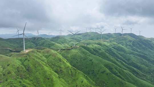 绿色山丘上的风力发电机群全景