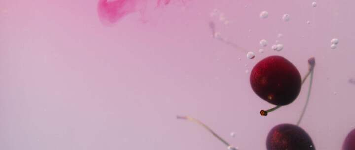 樱桃掉进粉红色的液体里