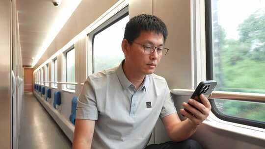 男子在卧铺火车过道上使用手机