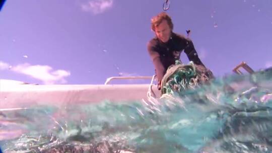 潜水员从海水中拉出旧渔网视频素材模板下载