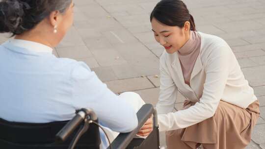 女儿为坐轮椅的母亲按摩康复身体