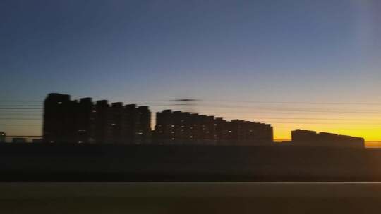 火车窗外的夕阳与城市