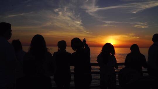 人们在海边观赏日落