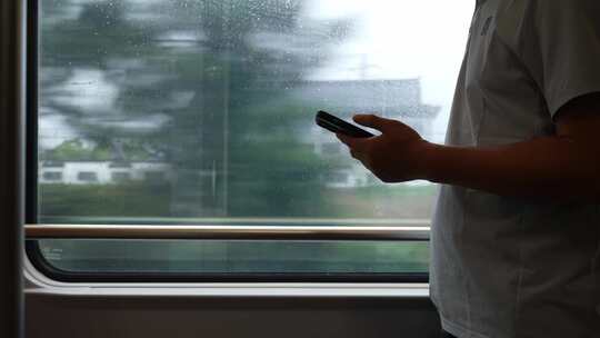 男子在卧铺火车过道上使用手机