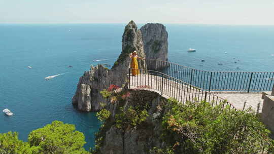 旅游妇女从卡普里岛俯瞰大海。一位游客正在