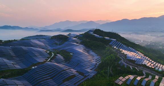 新能源太阳能光伏发电站夕阳下山坡航拍