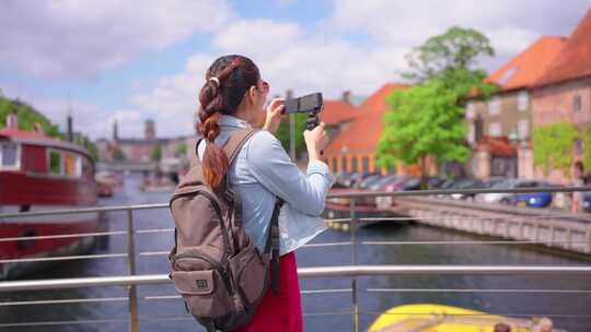 亚洲女性旅行者在城市旅行时使用相机记录v