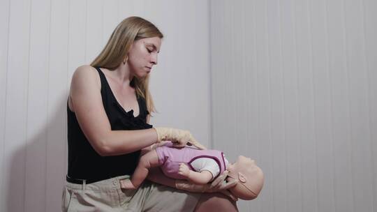 妇女学习如何在婴儿身上应用心肺复苏