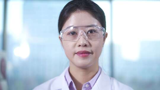 女性科研人员戴着护目镜在生物实验室做实验视频素材模板下载