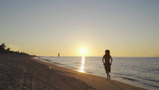 清晨日出美女走在海边奔跑沙滩跑步未来希望
