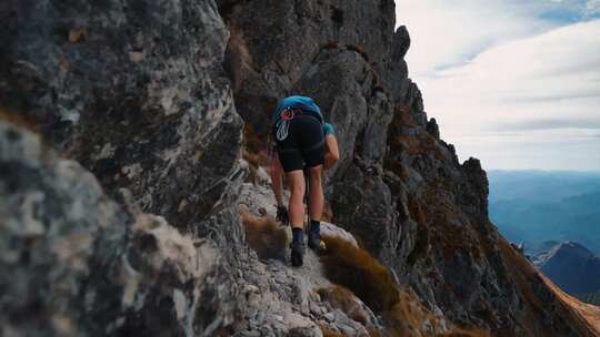 登山者手抓岩石攀登山峰