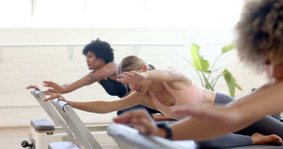 三名女性参与普拉提改造器锻炼，重点是形式